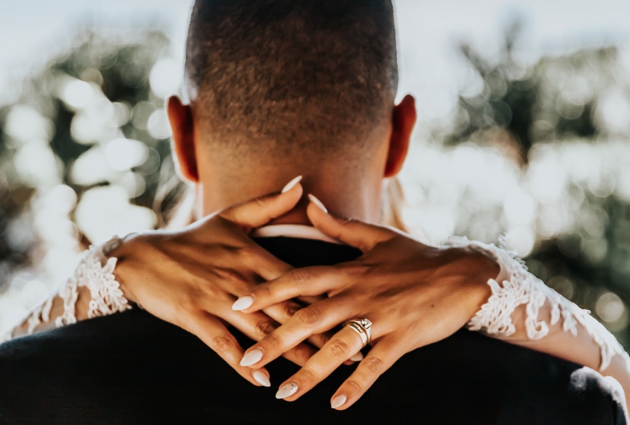 woman holding neck of man with ring on woman holding neck of man with ring on