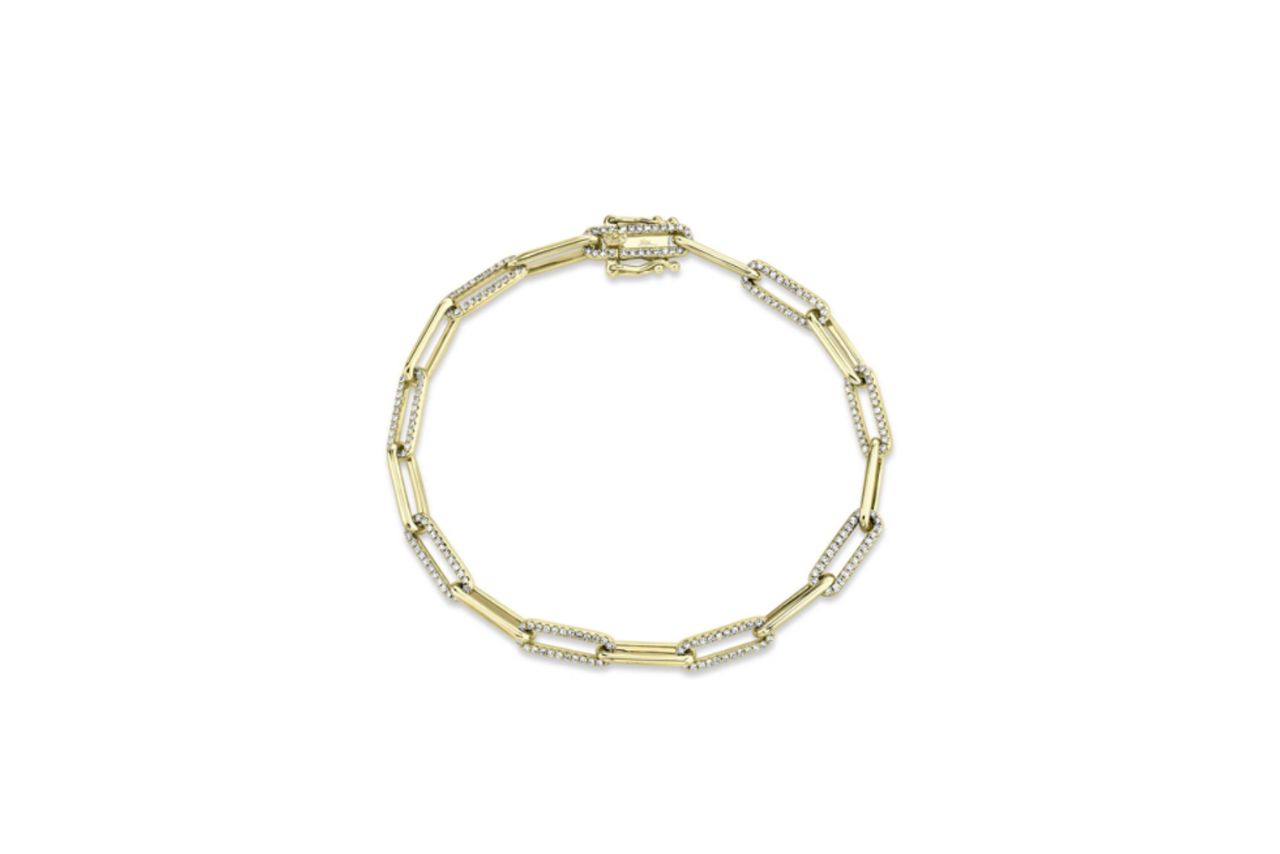 A golden chain link bracelet with some links adorning diamonds.
