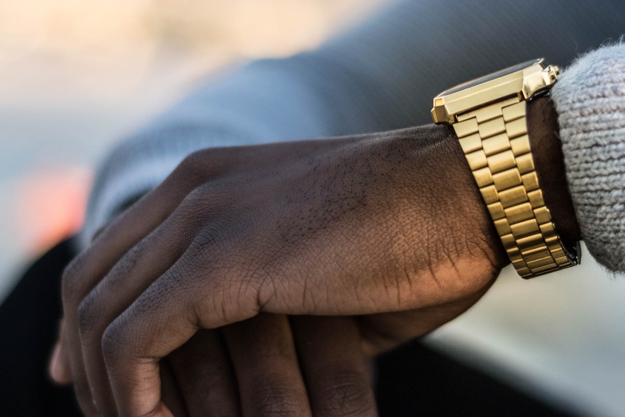 a man&rsquo;s hand wearing a gold watch