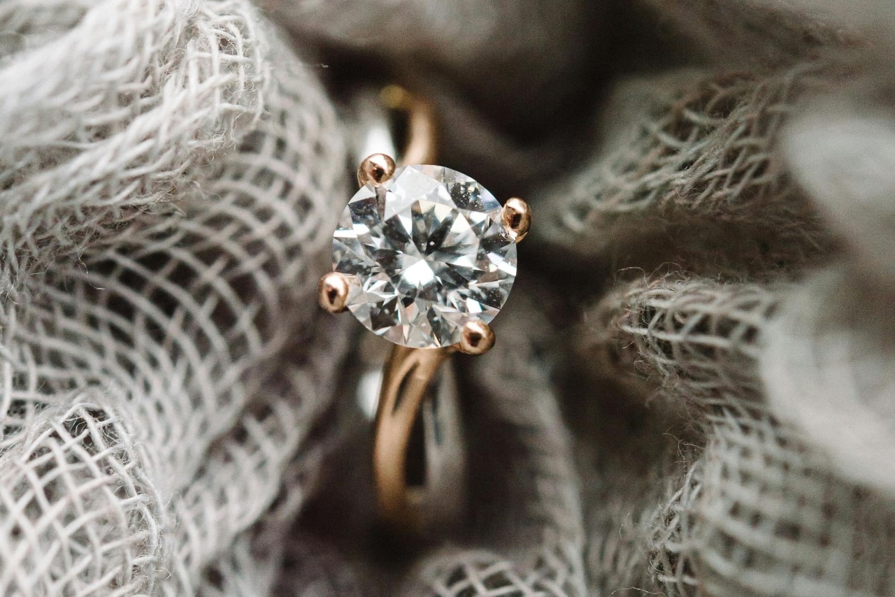 A yellow gold round cut diamond solitaire engagement ring