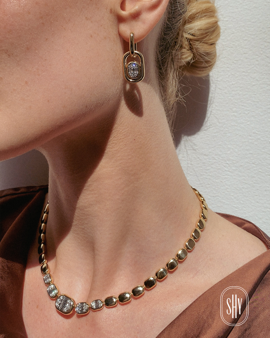 A woman wearing dimaond earrings and diamond necklace